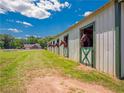 Horse barn with horses looking out the doors of their stalls on a sunny day at 1820 Walker Sw Rd, Conyers, GA 30094