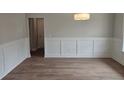 Bright dining room features elegant wainscoting, wood floors, and modern lighting at 3292 Lions Ruby Ln, Atlanta, GA 30349