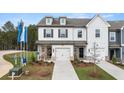 Inviting townhome featuring white siding, black shutters, attached garage, and a landscaped front yard at 281 Kenoot Dr # 36, Mcdonough, GA 30253