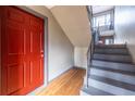 Inviting entryway with red door and staircase, creating a warm welcome at 410 Candler Park Ne Dr # C-1, Atlanta, GA 30307