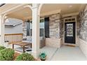 Inviting front porch featuring stone accents, stylish seating, and manicured landscaping at 1611 Saddlegate Dr, Canton, GA 30114