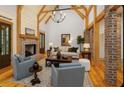 Inviting living room with vaulted ceilings, exposed wooden beams, a brick fireplace, and hardwood floors at 2731 Tribble Mill Rd, Lawrenceville, GA 30045
