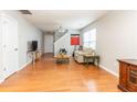 Bright living room with hardwood floors, neutral walls, and a staircase leading to the upper level at 176 Darbys Crossing Ct, Hiram, GA 30141