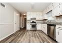 Bright kitchen featuring white cabinets, stainless steel appliances, and hardwood floors offering ample space and functionality at 1005 Quail Dr, Stockbridge, GA 30281