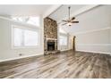 Spacious living room with a stone fireplace, vaulted ceiling, and large windows creates a warm, inviting atmosphere at 1005 Quail Dr, Stockbridge, GA 30281