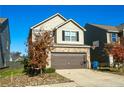 Two-story home featuring tan siding, brick accents, a two-car garage, and a well-manicured front yard at 264 Magnaview Dr, Mcdonough, GA 30253