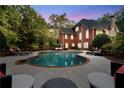 Inviting pool with surrounding lounge area, offering a perfect outdoor retreat with lush greenery at 2779 Horseshoe Knoll Ln, Roswell, GA 30075