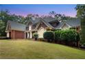 Brick home with manicured lawn and landscaping, complemented by elegant architectural details at 2779 Horseshoe Knoll Ln, Roswell, GA 30075