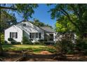 White house with black shutters, inviting front porch, and lush landscaping at 5154 Central Dr, Stone Mountain, GA 30083