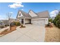 Charming home featuring a two-car garage, stone accents, and a beautifully landscaped front yard with black iron fencing at 117 Laurel Vw, Canton, GA 30114