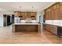 Spacious kitchen with a large center island, wooden cabinets, stainless steel appliances, and hardwood floors at 200 Heatherton Way, Milton, GA 30009
