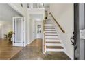 Inviting foyer with a staircase and tile flooring leading into a hallway with hardwood floors at 5450 Taylor Rd, Johns Creek, GA 30022