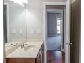 Well-lit bathroom with a large mirror, single sink vanity, and hardwood floors that extend into the bedroom at 2733 Madison Mae Ln, Grayson, GA 30017