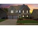 Two-story brick home with a large front yard and attached two-car garage, nighttime view at 4345 Settlers Grove Rd, Cumming, GA 30028