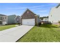 A beautiful exterior featuring a brick front, a two-car garage, and green lawn at 3745 Newbury Place Dr, Loganville, GA 30052