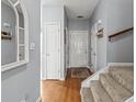 Inviting foyer with hardwood floors, neutral gray walls and a carpeted staircase leading to the upper level at 4405 Maple Valley Dr, Cumming, GA 30040