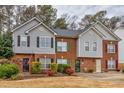 Street view of a row of charming townhomes with brick and gray siding exteriors and colorful accent shutters at 4405 Maple Valley Dr, Cumming, GA 30040