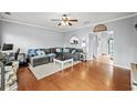 Spacious living room featuring hardwood floors, a comfortable sectional sofa, and ample natural light at 4405 Maple Valley Dr, Cumming, GA 30040