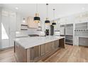 Spacious kitchen featuring a large island, white cabinets, stainless steel appliances, and hardwood flooring at 3661 Clubwood Trl, Marietta, GA 30068