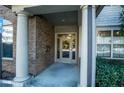 Close-up view of condo building entrance with brick pillars and accessible entrance at 4805 West Village Way # 3207, Smyrna, GA 30080