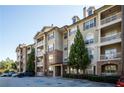 Exterior view of condo building with parking lot and surrounding landscaping at 4805 West Village Way # 3207, Smyrna, GA 30080