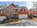 Charming two-story brick home featuring a two-car garage, inviting balcony, and manicured landscaping at 7775 Georgetown Chase, Roswell, GA 30075