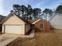 Brick and vinyl ranch home with a 2-car garage and mature trees at 754 Shore Dr, Lithonia, GA 30058