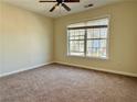 This bedroom features neutral walls and carpet, with a window view of the neighborhood at 7972 Applemist Dr, Fairburn, GA 30213