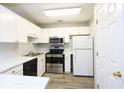 Clean kitchen with white cabinets, stainless steel appliances, and wood-look floors at 225 Bentley Pl, Tucker, GA 30084