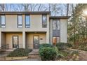 Tan two-story townhome with dark brown window frames and a lush green landscape at 54 Ivy Ne Pkwy, Atlanta, GA 30342