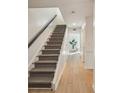 Modern light wood and grey herringbone patterned carpeted staircase at 54 Ivy Ne Pkwy, Atlanta, GA 30342