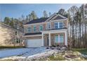 Two-story brick home with a white garage door and landscaping at 628 Leafy Branch Way, Mcdonough, GA 30253