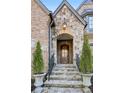 Inviting entryway with stone steps, arched doorway, and mature landscaping at 1031 Eulalia Ne Rd, Atlanta, GA 30319