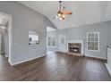 Inviting living room featuring a cozy fireplace, hardwood floors, modern lighting, and open layout at 287 Jenna Ln, Dallas, GA 30157