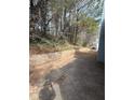 Backyard featuring a brick retaining wall and mature trees at 4815 Diggers Way, Sugar Hill, GA 30518