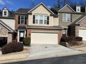 Tan and brown townhome with a two-car garage and landscaping at 5800 Oakdale Rd # 103, Mableton, GA 30126