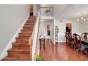 Entryway with hardwood floors, staircase, and views into the dining area and kitchen at 2013 Parador Bnd, Mcdonough, GA 30253