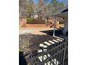 Landscaped backyard with a patio, retaining wall, and steps leading to a deck at 790 Hiram Davis Rd, Lawrenceville, GA 30045