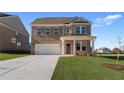 Two-story brick home with a white garage door and front porch at 245 Chiswick Loop, Stockbridge, GA 30281