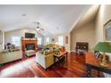 Bright living room with vaulted ceiling, fireplace, hardwood floors, and a ceiling fan at 5323 Lakesprings Dr, Dunwoody, GA 30338