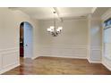 Formal dining room with hardwood floors, wainscoting, and chandelier at 876 Nevis Way, Mcdonough, GA 30253