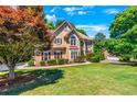 Two story house with tan siding, brown roof, and burgundy shutters at 234 Lake Ruby Dr, Suwanee, GA 30024