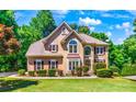 Two story house with tan siding, brown roof, and burgundy shutters at 234 Lake Ruby Dr, Suwanee, GA 30024
