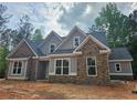Charming new home with stone accents and light gray siding nestled among mature trees at 6851 Phillips Mill Rd, Douglasville, GA 30135
