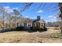 A cozy single-Gathering home with a charming exterior, surrounded by trees and a well-manicured lawn on a clear day at 446 Mcgukin Rd, Bremen, GA 30110