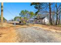 Brick ranch house with gravel driveway and fenced yard at 12205 Highway 36, Covington, GA 30014