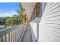 Long front porch with wooden posts and grey railings, overlooking a wooded area at 2815 Spain Dr, East Point, GA 30344