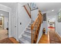 Light gray carpeted staircase with wooden railing and view into the kitchen at 2339 Milstead Cir, Marietta, GA 30066