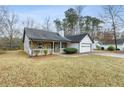 Traditional home featuring a stone facade, a covered porch, and a well-manicured front yard at 70 Ashton Pl, Covington, GA 30016