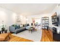 Bright living room with hardwood floors, modern furniture, and open dining area at 15 Kings Tavern Nw Pl, Atlanta, GA 30318